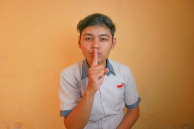 Endonezyalı erkek lise öğrencileri gri ve beyaz üniformalar giyerler. Sarı bir arkaplanda ve çok çeşitli ifadelerle izole edilmiş.