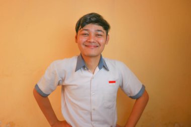 Endonezyalı erkek lise öğrencileri gri ve beyaz üniformalar giyerler. Sarı bir arkaplanda ve çok çeşitli ifadelerle izole edilmiş.