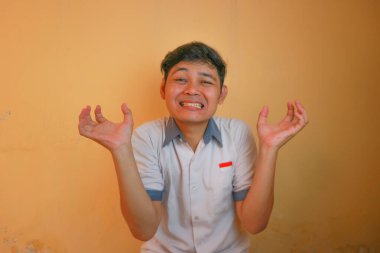 Endonezyalı erkek lise öğrencileri gri ve beyaz üniformalar giyerler. Sarı bir arkaplanda ve çok çeşitli ifadelerle izole edilmiş.