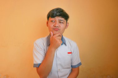 Endonezyalı erkek lise öğrencileri gri ve beyaz üniformalar giyerler. Sarı bir arkaplanda ve çok çeşitli ifadelerle izole edilmiş.