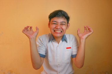 Endonezyalı erkek lise öğrencileri gri ve beyaz üniformalar giyerler. Sarı bir arkaplanda ve çok çeşitli ifadelerle izole edilmiş.