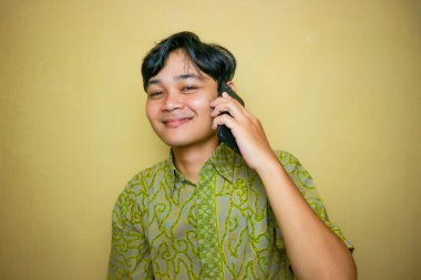 Ulusal Batik Günü 'nde Batik kıyafetler giyen Asyalı Endonezyalı bir adam.