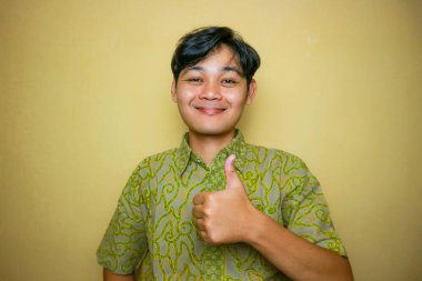 Ulusal Batik Günü 'nde Batik kıyafetler giyen Asyalı Endonezyalı bir adam.