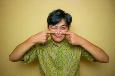 Ulusal Batik Günü 'nde Batik kıyafetler giyen Asyalı Endonezyalı bir adam.