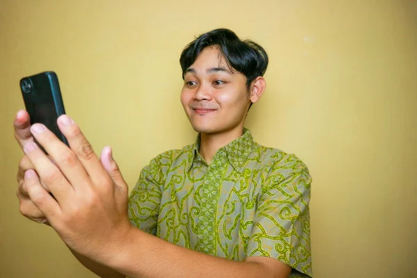 Ulusal Batik Günü 'nde Batik kıyafetler giyen Asyalı Endonezyalı bir adam.