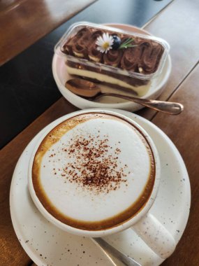 Tahta bir masada krem şantili lezzetli çikolata tatlısı.