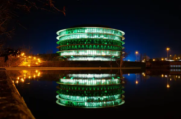 Bina geceleri küçük göle yansıyor.