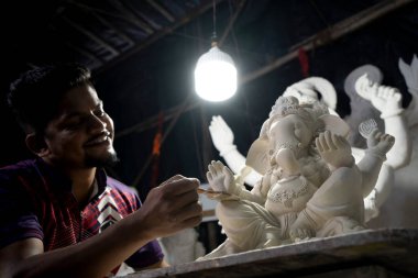 Mumbai, Hindistan 29 Ağustos 2023 Ganesha 'da Ganesha Chaturthi Festivali' nin önünde Ganesha renkli Ganesha idolü üzerinde çalışan bir sanatçı.