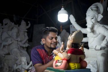 Mumbai, Hindistan 29 Ağustos 2023 Ganesha 'da Ganesha Chaturthi Festivali' nin önünde Ganesha renkli Ganesha idolü üzerinde çalışan bir sanatçı.