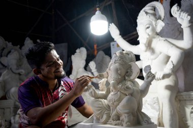 Mumbai, Hindistan 29 Ağustos 2023 Ganesha 'da Ganesha Chaturthi Festivali' nin önünde Ganesha renkli Ganesha idolü üzerinde çalışan bir sanatçı.