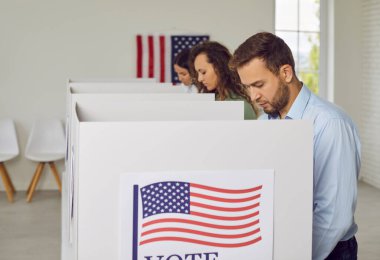 Amerikan vatandaşları oy merkezindeki oy kullanma merkezinde sıra sıra bekleyen ABD 'li seçmenler biz bayraklar oy pusulalarını oy kabinine koyacaklar. Demokrasi ve seçim günü konsepti.