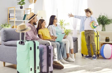 Dört kişilik mutlu bir aile, çocuklar bilet alıyor ve internetten otel rezervasyonu yapıyorlar. Evdeki kanepede dizüstü bilgisayarla yaz tatilini bekleyen bavullarıyla oturuyorlar. Tatil gezisi konsepti.