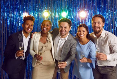 Grup portre çalışanları, yeni yıl partisindeki arkadaşlar soyut ışıl ışıl arka planda ellerinde şampanya kadehleriyle kameraya bakıp gülümsüyorlar. Noel ruhu, kış tatili konsepti.