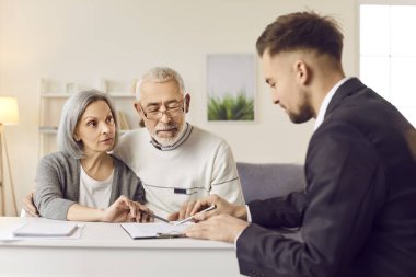 Yaşlı çift emlakçıyla yeni bir emlak sözleşmesi imzalamayı kesinleştiriyor. Emlak acentesinde emlak sözleşmesi imzalayan üst düzey bir çift emlakçıyla sözleşme imzaladı.