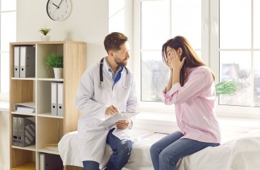 Kadın hasta, başağrısı ya da migren konsültasyonu için hastanede bir doktora ya da hemşireye başvuruyor. Hekim ağrı kesici için tavsiye ve tedavi seçenekleri sunar..