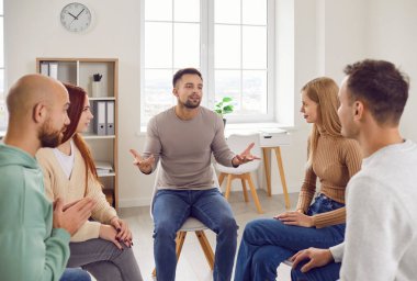 Profesyonel psikoterapist genç yetişkinler grubuna önderlik ediyor, erkek ve kadın hastaların grup terapi faaliyetleri yoluyla zihinsel sağlık sorunlarını tedavi etmelerine yardımcı oluyor. Grup terapi konsepti. 