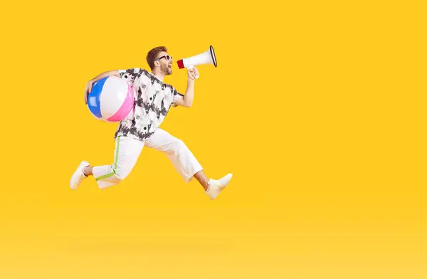 一个穿着休闲装 头戴充气海滩球的滑稽青年游客的肖像 在工作室黄色的背景上 嘴里尖叫着 跳跃着 度假旅行和暑假的概念 — 图库照片