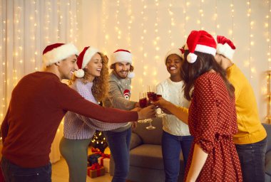 Gülümseyen çok ırklı arkadaşlar kodes şişeleri evde birlikte yeni yılı kutluyorlar. Mutlu uluslararası çeşitli insanlar Noel kutlaması ya da partinin tadını çıkarıyor. Kış tatili kavramı.
