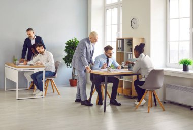 Bir grup iş adamı ve kadın işyerlerinde konuşuyor. Şirket çalışanları büroda çalışıyor, iş ve iş projelerini tartışıyorlar. Takım çalışması konsepti.