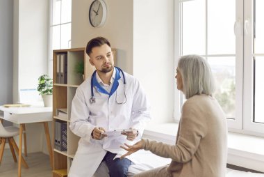 Yaşlı kadın hasta hastane muayenehanesi sırasında bir doktor veya hemşireye danışmanlık yapmaktadır. Bu danışma, yaşlı hasta sağlık hizmetlerinin bir parçasıdır..