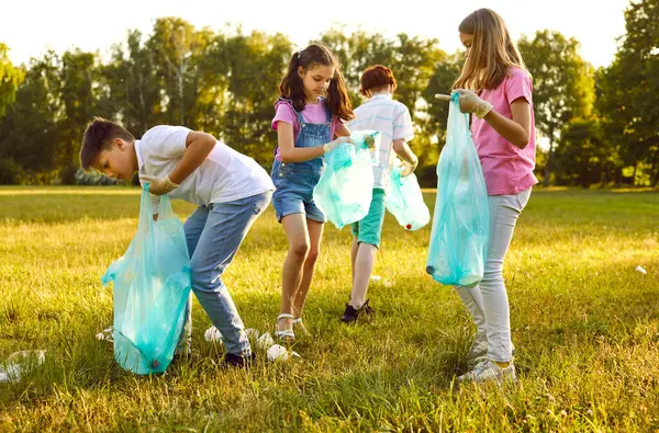 10代の子供たちのグループは 屋外の夏の公園でゴミを収集する手袋やゴミ袋でボランティアをしています 子供や少女が環境汚染を浄化する エコロジーコンセプト — ストック写真