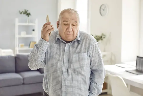 Elderly Man Looks Puzzled Talking Mobile Phone Call Home Engaged — Stock Photo, Image