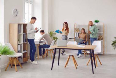 Genç iş adamlarından oluşan bir grup. Günlük giysiler içindeki kadın ve erkekler işyerlerinde konuşuyorlar. Şirket çalışanları ofiste çalışıyor, iş ve iş projelerini tartışıyor. Takım çalışması konsepti.
