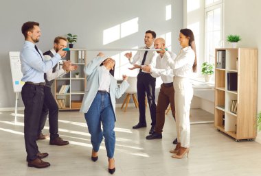 Bir grup mutlu genç iş adamı şirket çalışanları ofiste çalışan iş arkadaşları arasında sopayla yarışmalar düzenlerken eğleniyorlar. Takım çalışması, şirket kurma ve başarı kavramı..