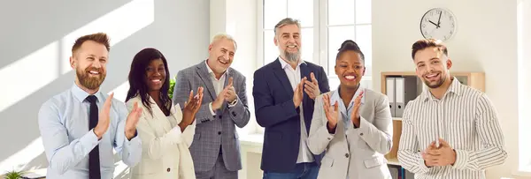 stock image Group of multiethnic happy business people men and women looking at the camera, smiling and applauding. Company employees team or a group of staff standing in the office cheerfully. Banner.