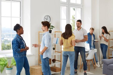 Çok ırklı bir grup güzel genç, güneşli bir yaz gününde ofiste öğle yemeği arasında sohbet etmek için bir araya geldi. Öğle yemeği molasında yaratıcı çok ırklı iş grubu.