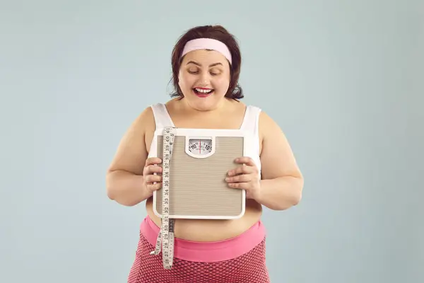 Glückliche Size Übergewichtige Frau Sportkleidung Mit Gewichtswaage Lächelnde Pummelige Dicke lizenzfreie Stockbilder
