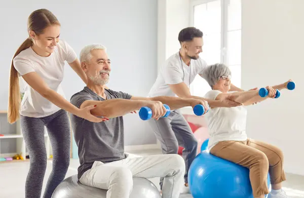 Coach Health Care Worker Helping Mature People Sport Exercises Dumbbells Stock Photo