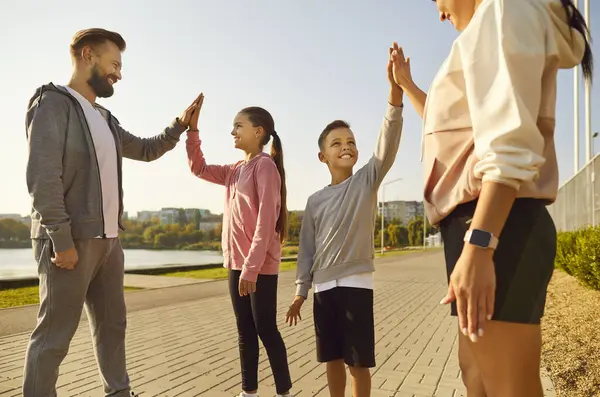 Happy Smiling Sporty Family Children Giving High Five Each Other Stock Photo