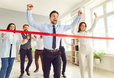 Ofisteki kırmızı bitiş çizgisini koşan ve geçen iş adamı, meslektaşları zaferi, başarıyı ve başarıyı desteklerken, işadamı kazanan olarak ortaya çıkıyor..