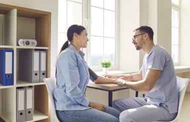 Kadın hasta için doktor kanı ölçümü, muayene için doktor muayenehanesi, yardım, düzenli kontrol, tarama testi. Kadın ve erkek hemşire, tıbbi teşhis ve hastalık tedavisi sunuyor.