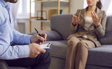 Psikiyatrist, psikosososyal destek için psikiyatrik doktor seansı, yardım, yazma formu, konuşma. Hasta ve klinik kayıtlarını tut. Hasta kadınla koltukta semptomları tartış.