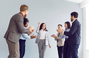 Çok uluslu mutlu ofis iş ekibi, meslektaşlarını alkışlayan bir grup, bir iş toplantısında onun başarısını kutluyor. Takım çalışması ve destek, olumlu ve teşvik edici çalışma ortamı.