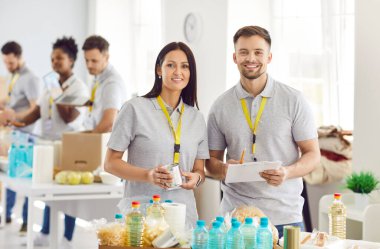 Gençler hayır kurumunda gönüllü olarak çalışıyor, yardıma muhtaç insanlara bağışta bulunuyorlar. Bağış, bağış şeyleri, temel ihtiyaçlar, bedava yemek, ihtiyacı olan insanlar için su, gıda bankası.