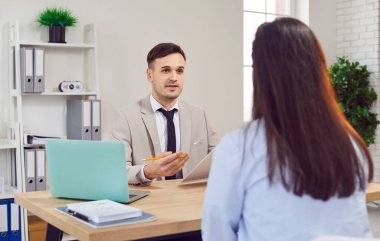 Mutlu iş adamı verimli bir ofis toplantısı sırasında bir müşteri veya meslektaşıyla tartışır. Bu sahne, ortak hedefler doğrultusunda birlikte çalıştıkları takım çalışmasını ve işbirliğini gösteriyor..