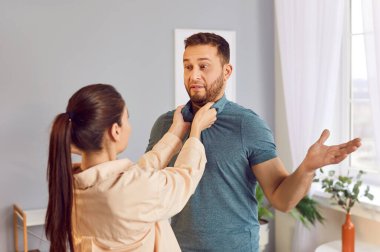 Kadın, evdeki bir çatışma sırasında kocasını tehdit ediyor. Aile içi şiddet ve istismar olaylarında korku ve öfke sıklıkla görülür. Aile dinamiği içindeki mağdurların hassasiyetini vurgular..