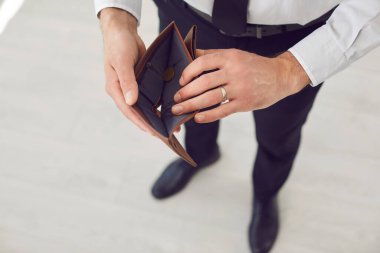 Resmi kıyafetler giyen fakir bir işadamının elinde boş bir cüzdan ve satın alacak parası olmadığının en üst görüntüsü. Ekonomik iflas, mali kriz ve işsizlik kavramı.