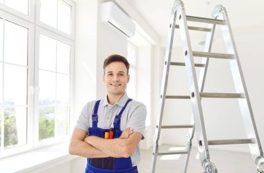 Mutlu bir adamın portresi, yetenekli bir işçi, ayakta durup gülümseyen bir ev onarıyor. Tamirci kendini işine adamış, mutlu bir tavırla profesyonel işi ve hizmeti garantiye alıyor..