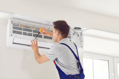 Klima tesisatı, kalifiye tesisat teknisyeni tarafından yerleştirilmiş. Profesyonel elektrikçi, modern duvar klimasını, oda tamircisini, klimayı tamir ediyor.