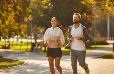 Mutlu sağlıklı, aktif bir çift sporcu erkek ve kadın aile dışarı koşar. Erkek, dişi sporcu koşu, koşmanın etkinliği, birlikte spor yapmak, dinamik ısınma.