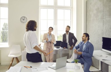 Başarılı genç erkek antrenör ya da konuşmacı, çeşitli iş arkadaşlarıyla ofiste bir araya geldi. Güvenilir genel iş adamı veya CEO çalışanlara sunum yapıyor. Liderlik kavramı.