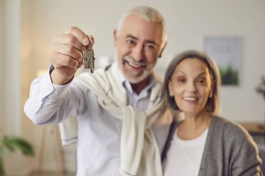 Mutlu yaşlı çift, hayatlarında yeni bir sayfa açmanın anahtarlarını taşıyor. Son sınıf karı koca yeni evin anahtarlarını tutarken birlikte gülümseyerek yeni evin anahtarlarını tutan yatırımı kutluyorlar.