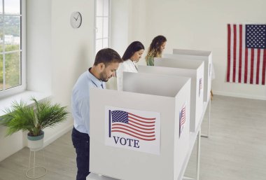 Amerikan vatandaşları oy merkezindeki oy kullanma merkezinde sıra sıra bekleyen ABD 'li seçmenler biz bayraklar oy pusulalarını oy kabinine koyacaklar. Demokrasi ve seçim günü konsepti.