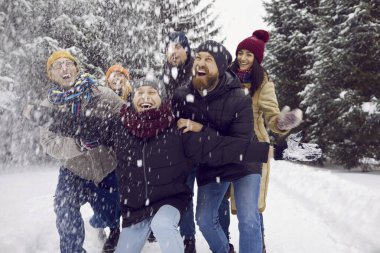 Dış giysili aşırı neşeli genç insanlar kış tatillerinin ya da açık havada tatilin tadını çıkarıyorlar. Gülümseyen arkadaşlar hafta sonu kar ormanlarında ya da parkta eğlenirler. Arkadaşlık kavramı.