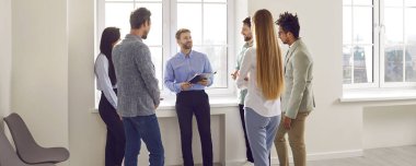 İş koçu ya da takım menajeri gençlerle iletişim kuruyor. Ofis penceresinin yanında duran ve çeşitli, çok ırklı insanlarla konuşan bir adam. Sancak, başlık arkaplanı