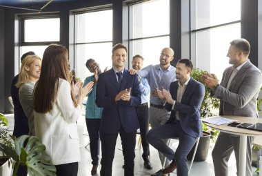 İş dünyasının büyük başarısı, iyi iş başarısı ya da iş promosyonu ile iş adamlarını tebrik eden dost canlısı ve çeşitli çalışanlar, modern ofiste iş adamlarını alkışlayan ve tezahürat yapan insanlar.